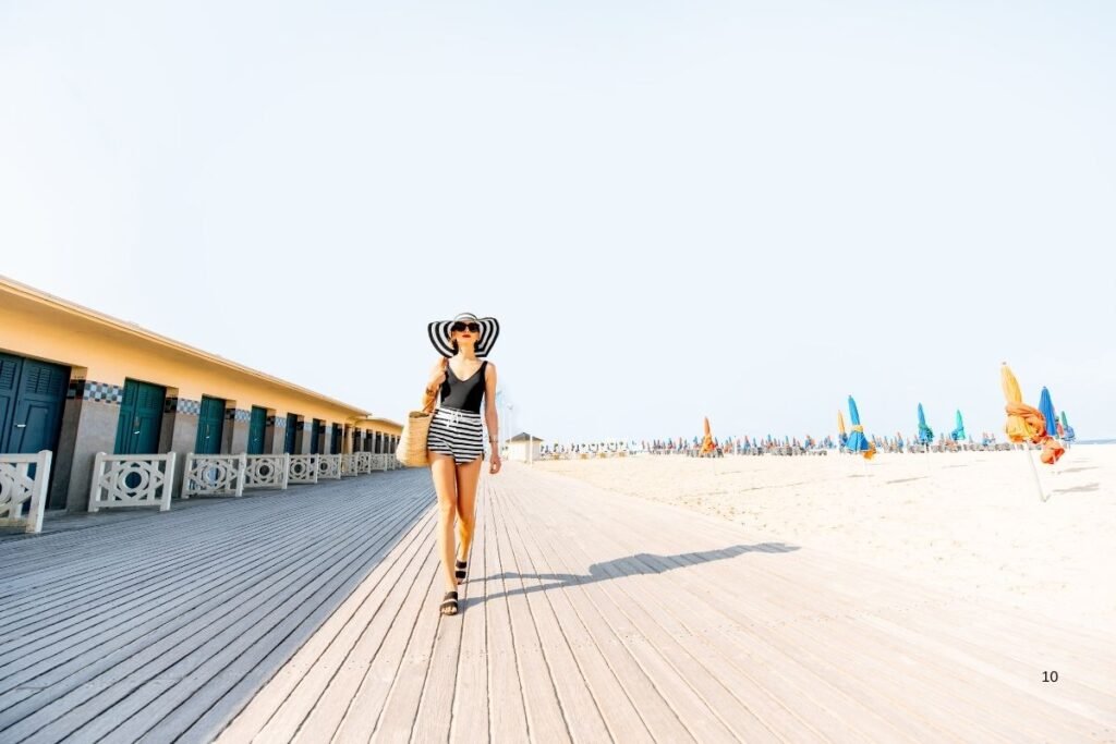 Woman walking on beach boardwalk. France