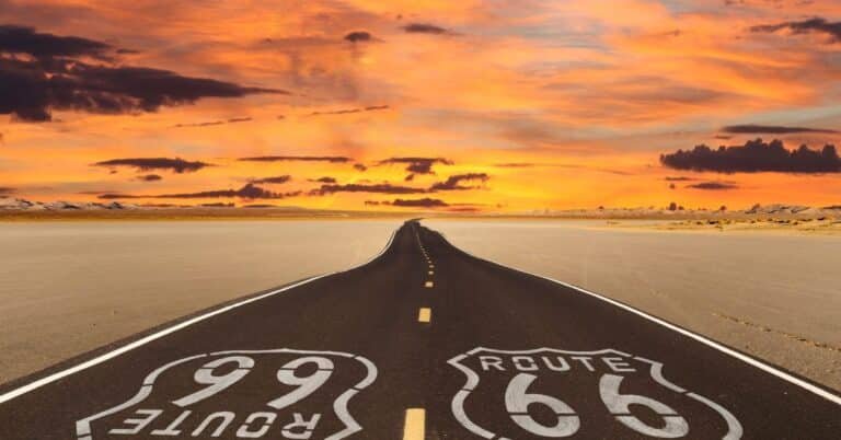 Desert road under a colorful sunset.
